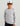 Child wearing white and gray fish-print long-sleeve crew shirt with blue logo on chest.