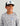 Child wearing gray fish-print crew neck shirt and white and black baseball cap with fish graphic.