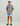 Child wearing gray Huk hoodie with blue logo, orange pocket trim, and blue patterned shorts with matching cap.