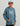 Child wearing slate blue Huk hoodie with large logo print, front kangaroo pocket, and drawstring hood.