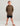 Child wearing brown fleece hoodie with green graphic text and black shorts.