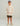 Child wearing cream hoodie with red text, camo shorts, and tan boat shoes.