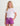 Girl wearing white t-shirt with coral logo and purple volley shorts with white drawstring.