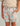 Kids' swim shorts with teal, coral, and cream all-over print featuring dinosaurs, water, and plant motifs with gray drawstrin