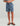 Kid wearing blue shorts with shark pattern on a plain background