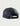 Navy mesh trucker hat with striped front panel, circular patch on crown, and adjustable snap closure back strap.