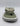 Olive and tan camouflage flip-flop with gray toe strap and white sole, viewed from front.