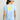 Light blue women's v-neck tee with yellow sunset graphic featuring palm tree and sun circle design on back.